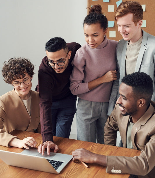 A group of people looking at a laptop