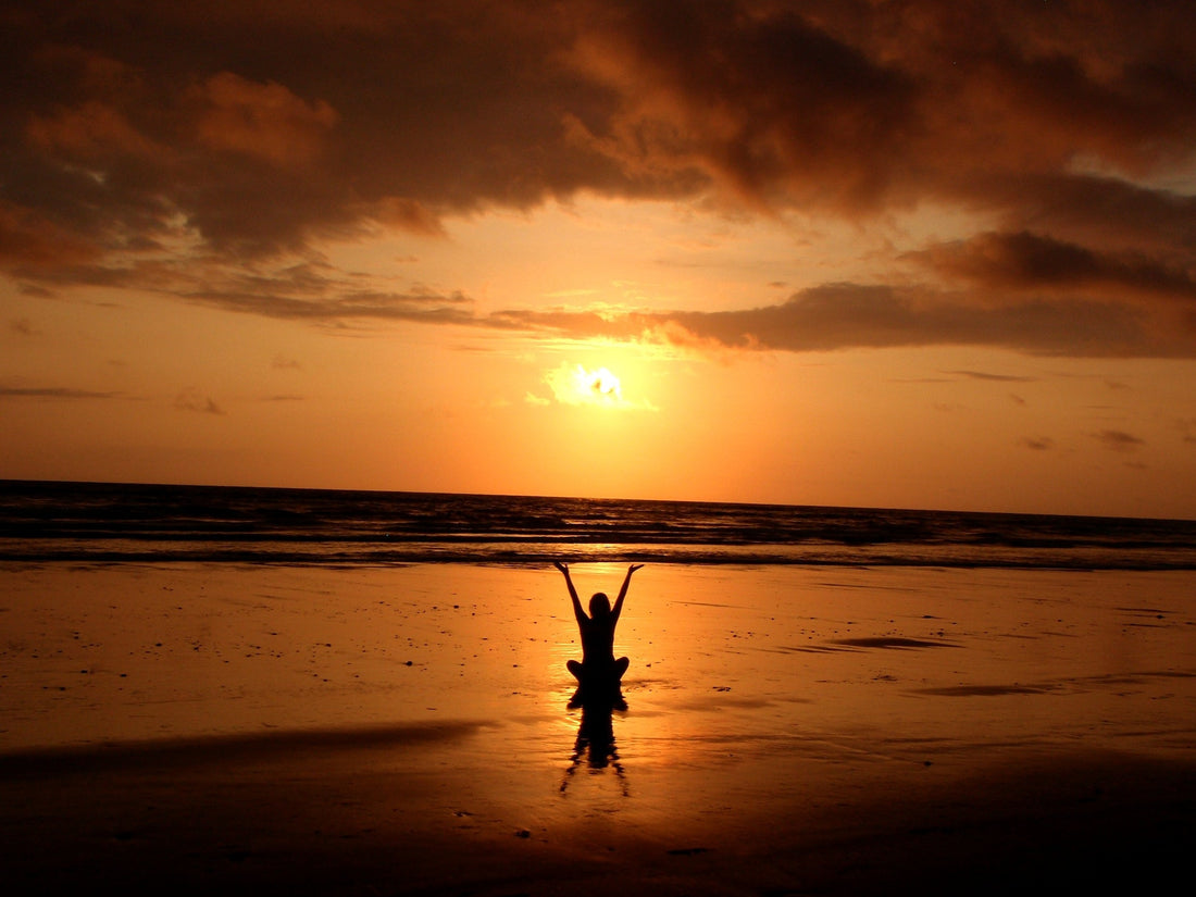 someone meditating in the sunset