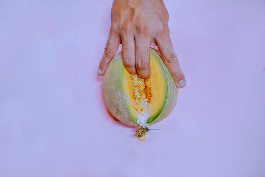 a picture of a melon with two fingers going into it