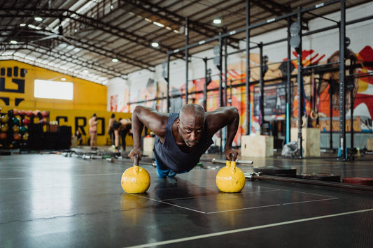 man doing push-ups with  kettlebells