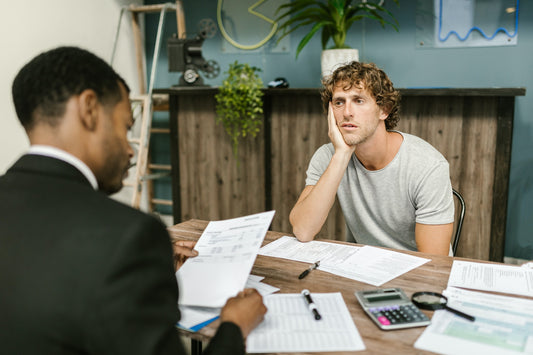 two men at a table discussing debt